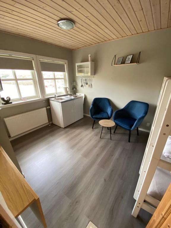 Miðvágur克里斯蒂安港度假屋的一间带两把椅子、一张桌子和一个水槽的房间