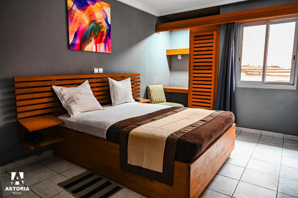 杜阿拉Hotel Astoria的一间卧室设有一张大床和一个窗户。