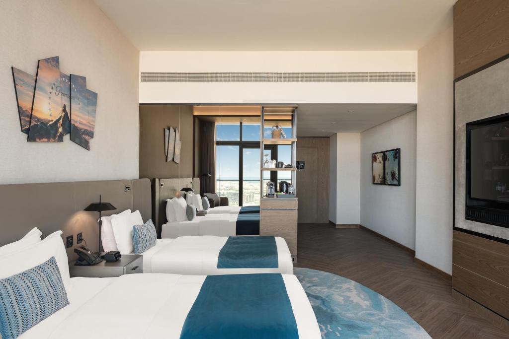 迪拜Paramount Hotel Midtown的酒店客房设有两张床和一台平面电视。