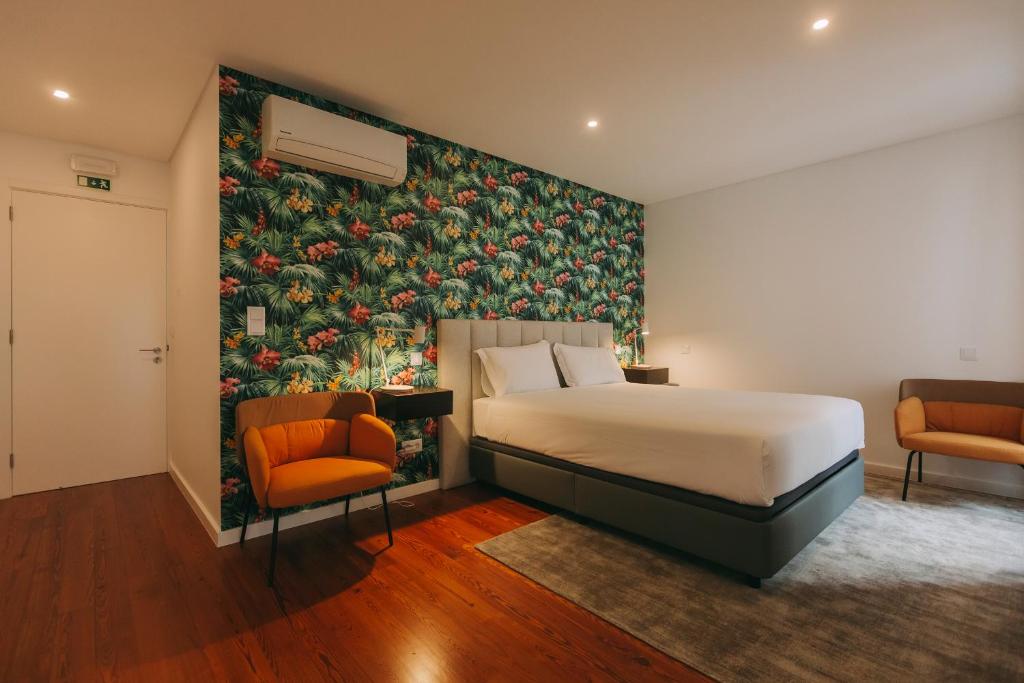 蓬塔德尔加达Azores Inn - Family Suites的酒店客房,配有一张床和两把椅子