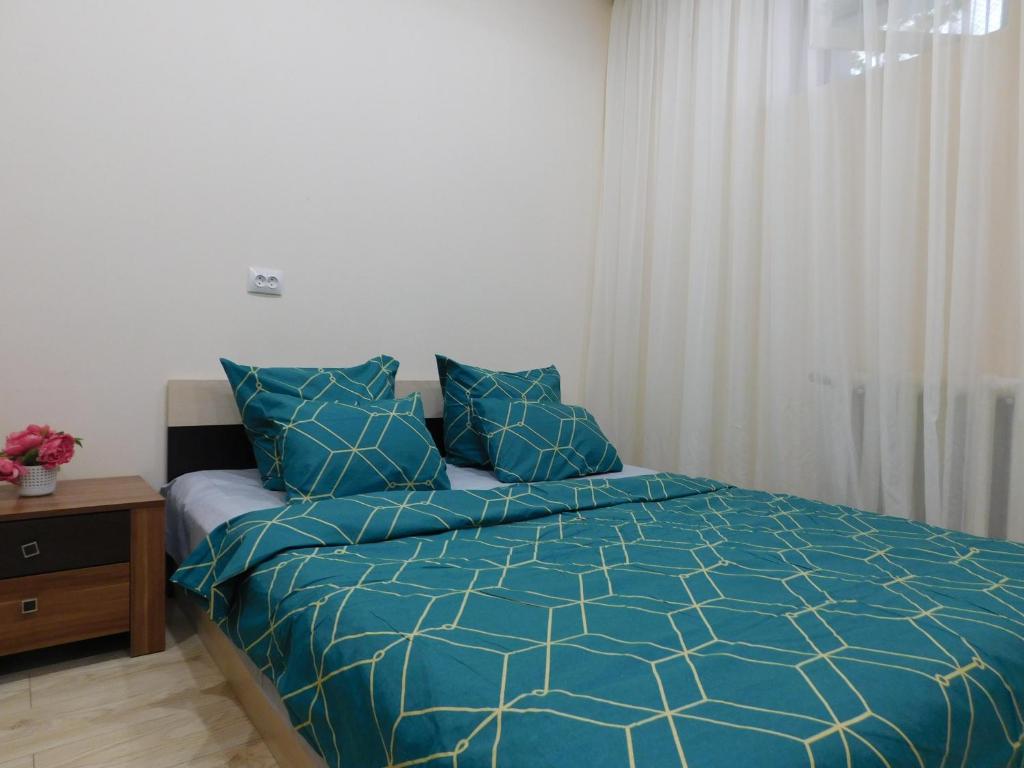 派蒂哥斯卡Апартамент в курзоне пр Кирова 7的一间卧室配有一张带蓝色棉被的床
