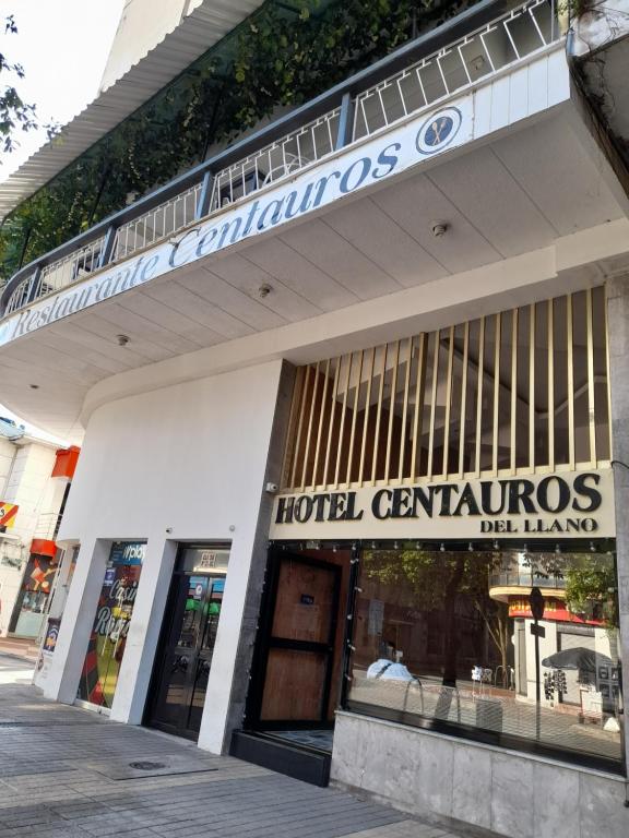 比亚维森西奥Hotel Centauros del Llano的大楼前的旅馆中央标志