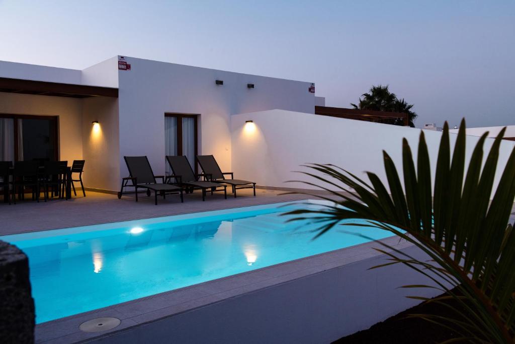 普拉亚布兰卡Villas Altos de Lanzarote的夜间带游泳池的别墅