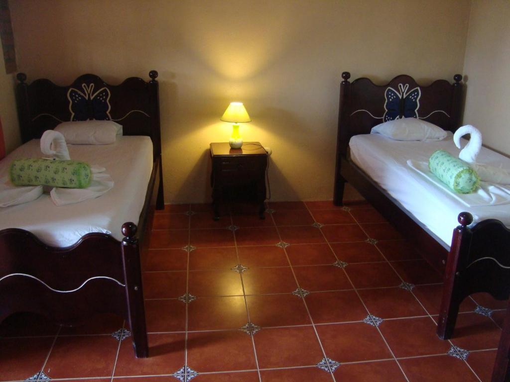 CárdenasEcolodge Blue Morpho的客房设有两张床和一张带台灯的桌子。