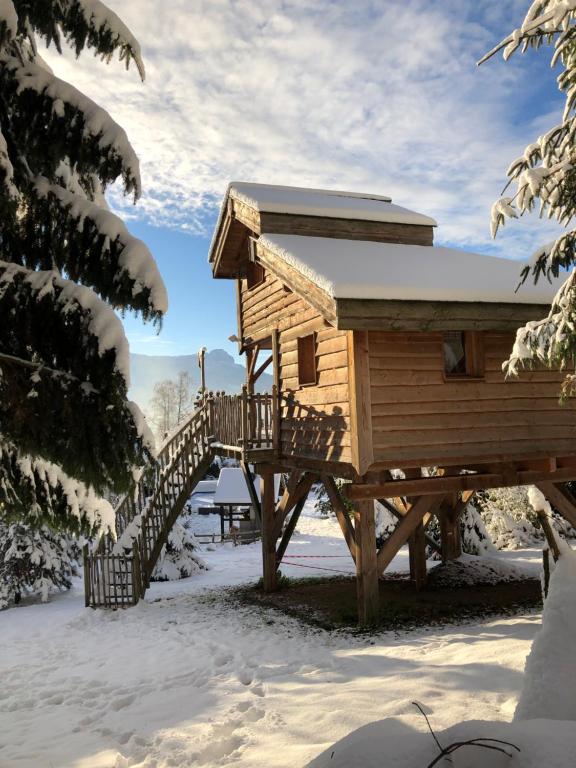 埃维尔La Cabane à l'Orée des Bornes的雪地中的小木屋,设有木楼梯