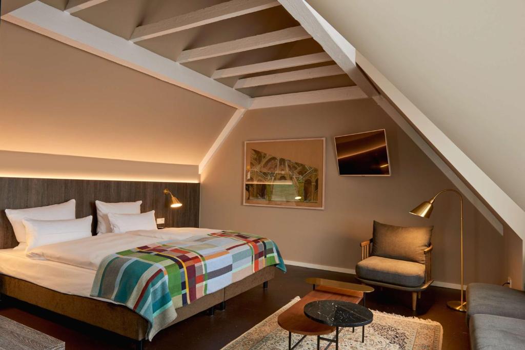 明斯特Central Hotel Münster的配有一张床和一把椅子的酒店客房