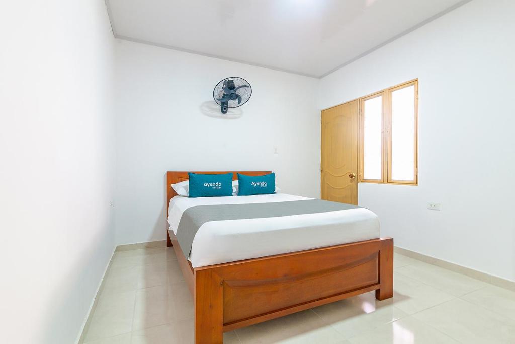 巴耶杜帕尔Hotel Tu Casa Bambú的一间卧室配有一张带蓝色枕头的床。