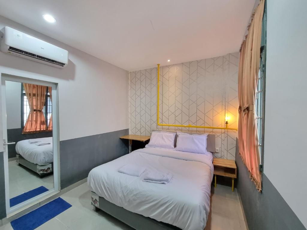 棉兰Super OYO Capital O 90874 Millenium Inn 2的一间卧室配有一张床和镜子