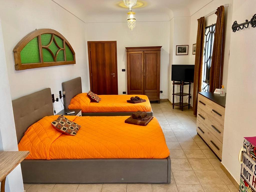 加拉蒂纳Casa di Marco的配有橙色床单的客房内的两张床
