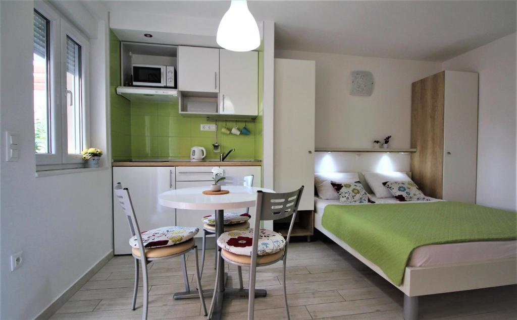 巴什卡沃达Apartments Adria的小房间设有一张床、一张桌子和椅子