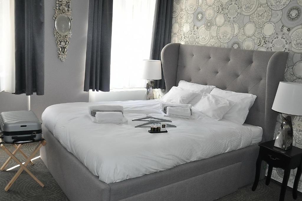 布达佩斯Váralja Home的卧室配有一张带白色床单的大床和大型床头板