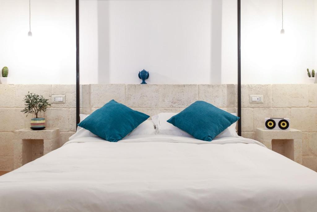 曼弗雷多尼亚D'Angiò Rooms-Manfredi Homes&Villas的一张带蓝色枕头的大型白色床