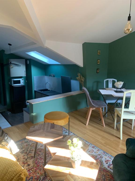 鲁昂Magnifique Appartement Neuf Vieux Rouen的客厅设有绿色的墙壁和桌椅