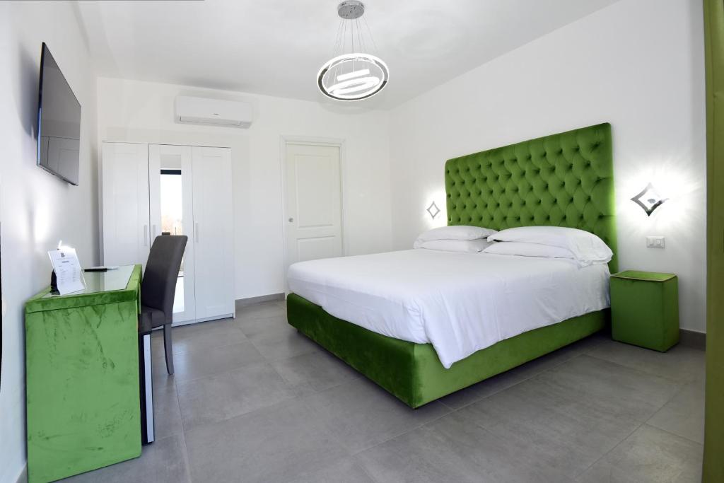 瓦尔蒙托内Agriturismo Borgo Imperiale的一间卧室配有一张大床和绿色床头板
