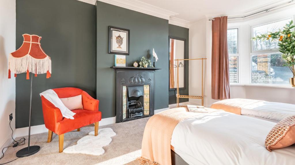 纽波特Tŷ Hapus Newport - Luxury 4 Bedroom Home的一间卧室配有红色椅子和壁炉