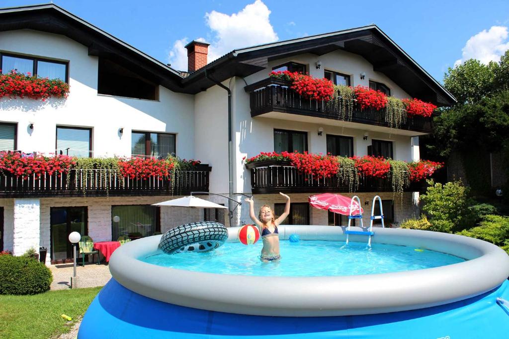 拉多夫吉卡Garden Apartments Janša的妇女在房子前面的游泳池里