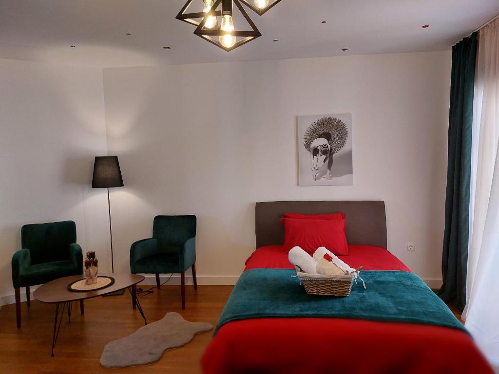 波德戈里察Aria Apartmani的一间卧室配有红色的床和两张绿色椅子