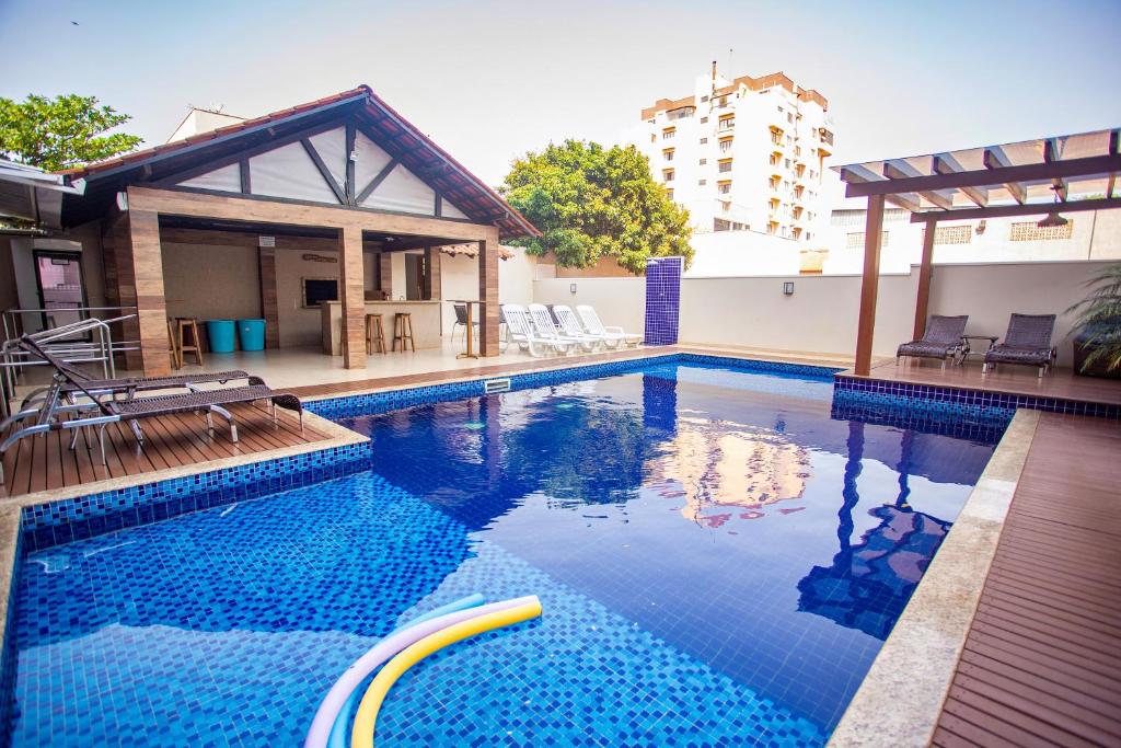 托莱多Nayru Hotel的一座带椅子的游泳池以及一座建筑