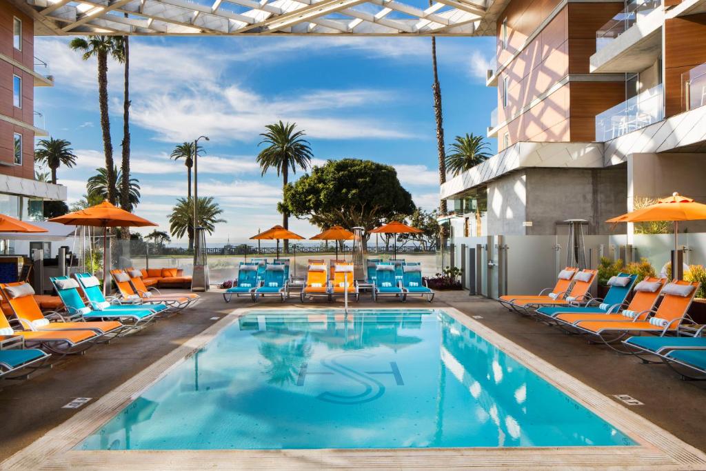 洛杉矶圣塔莫尼卡海滨酒店的游泳池,带椅子和遮阳伞