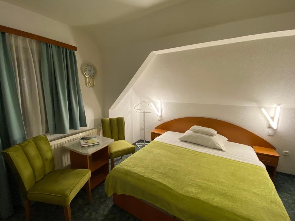 赫维兹瓦莱里亚别墅酒店的酒店客房带绿床和椅子