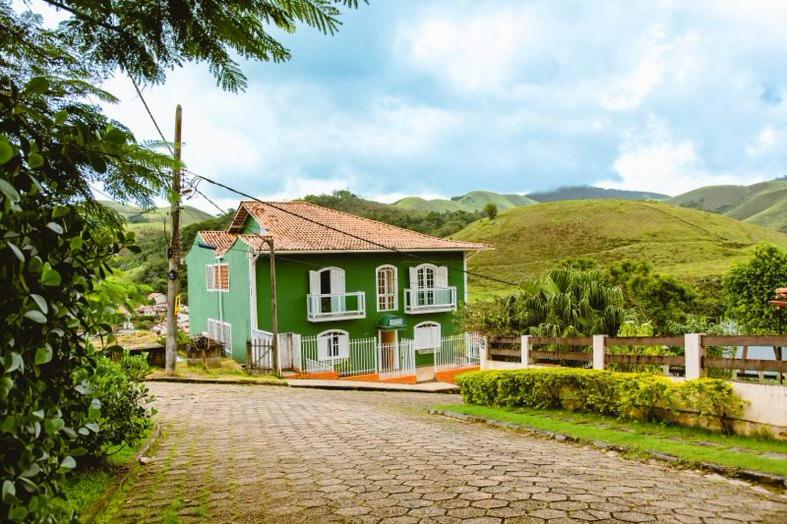 康赛瓦托利亚Pousada Conservatória的绿色白色的房子,有鹅卵石街道