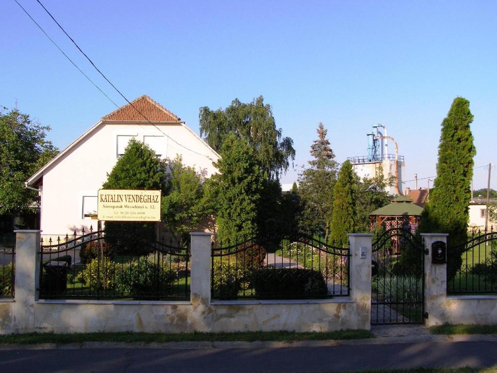 沙罗什保陶克Katalin vendégház的白色房屋前的围栏,有标志
