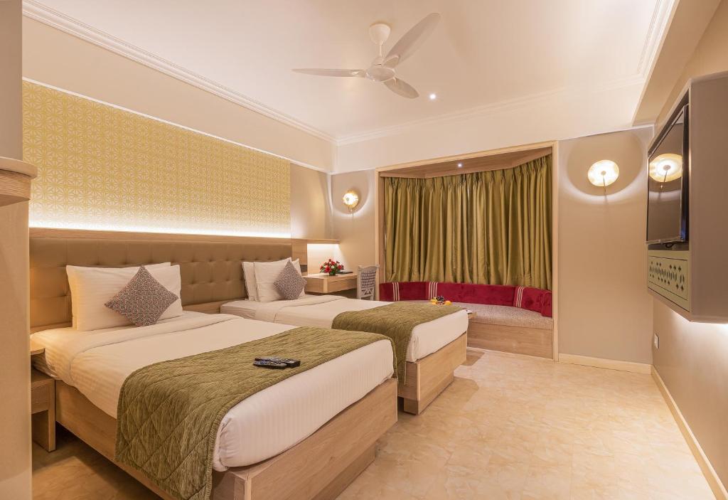 孟买滕伽乐园酒店的酒店客房设有两张床和电视。