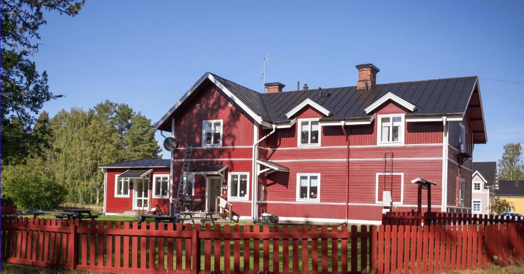 FurudalFurudals Vandrarhem och Sjöcamping的红墙后面有黑色屋顶的红色房子