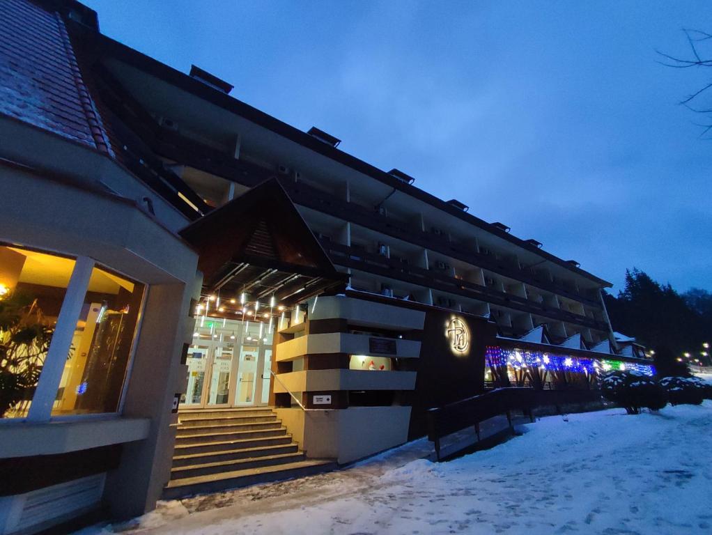 伯伊莱图什纳德丘卡什酒店的雪中带灯的建筑物