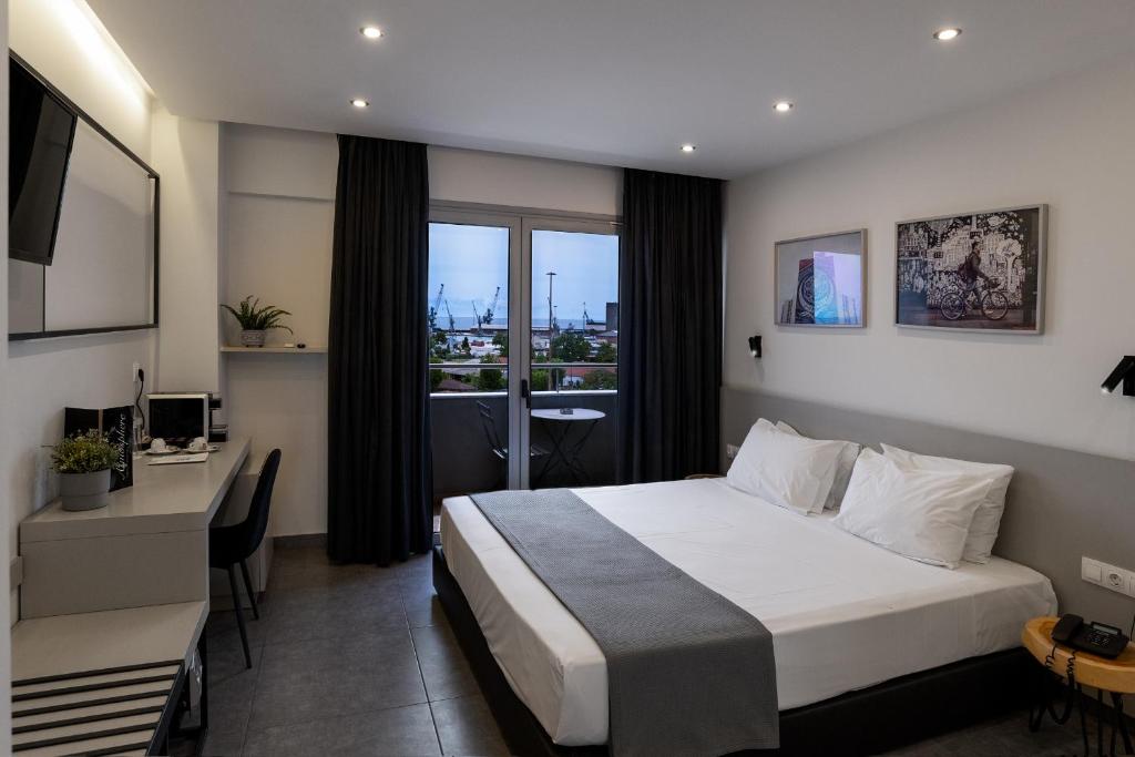 塞萨洛尼基White Luxury的配有一张床、一张书桌和一扇窗户的酒店客房