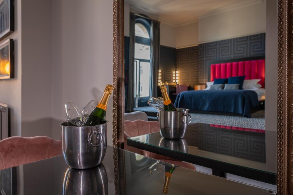 利物浦62 Castle Street Hotel的一间设有镜子和茶几的香槟酒的房间