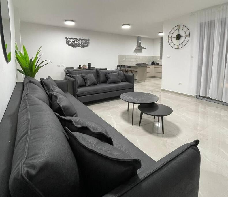 马格达拉Halom Olami- Villat Hashizaf的客厅配有黑色沙发和桌子