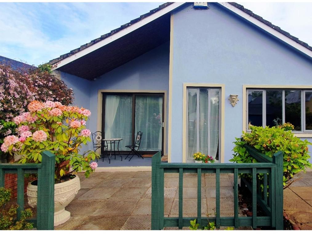 卡斯莱兰Home Comforts的蓝色房子,带鲜花门廊