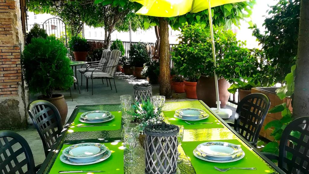 Casas del CastañarLas Glicinias的绿色桌子,上面有盘子和玻璃杯