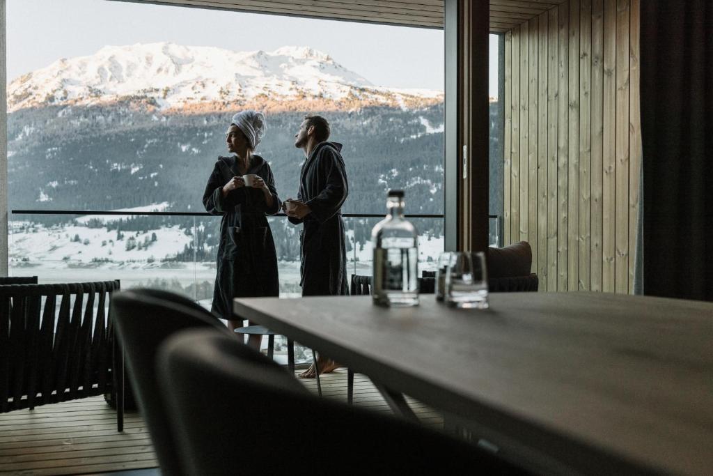 库龙韦诺斯塔Lacumontes Lake View Apartments的两名妇女站在一张桌子前,享有美景