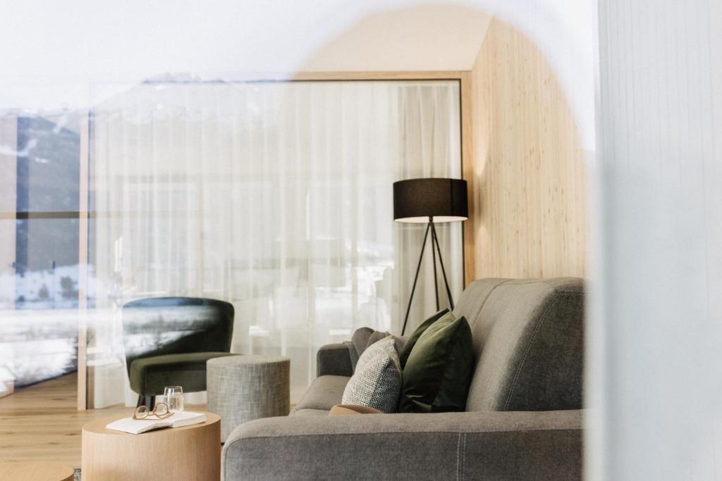 库龙韦诺斯塔Lacumontes Lake View Apartments的客厅配有灰色的沙发和椅子