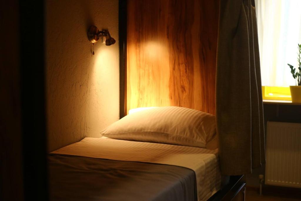第比利斯Hostel Nomad的窗户客房内的小床