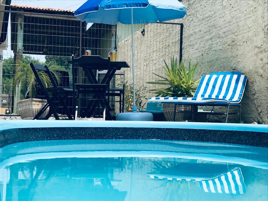 圣加布里埃尔Cantinho Dom Inácio的一个带遮阳伞和桌椅的游泳池
