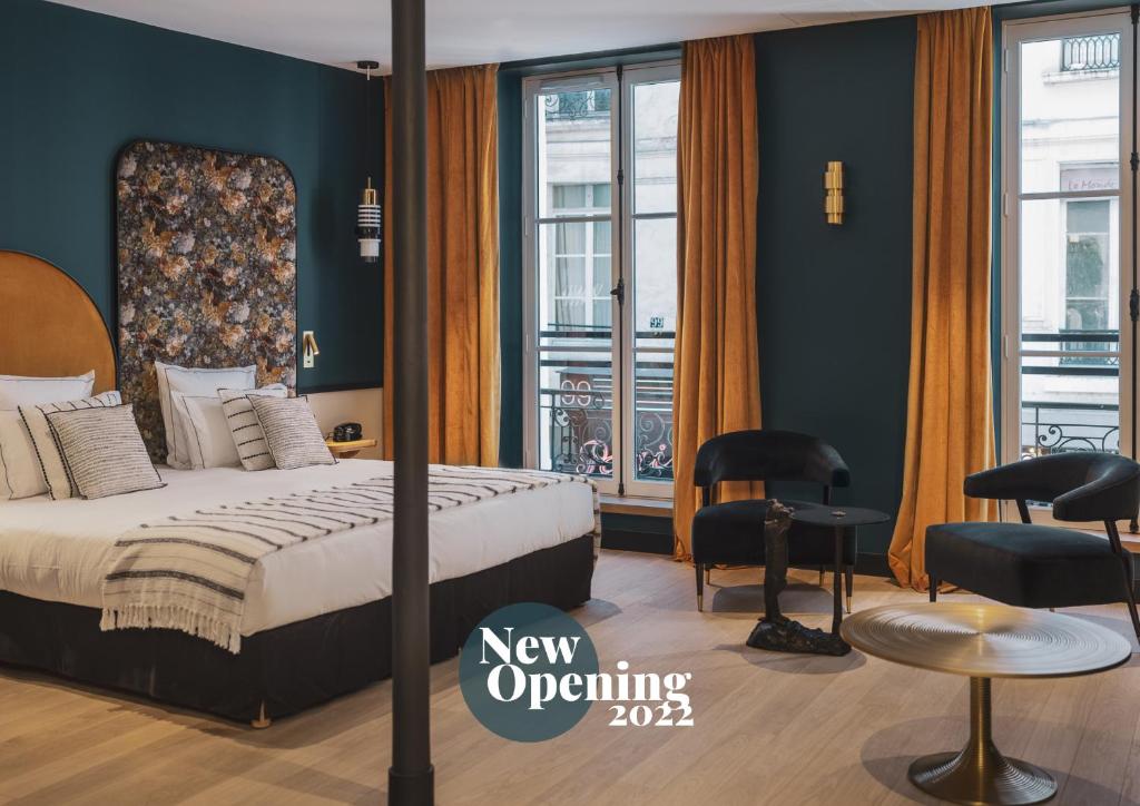 巴黎Dandy Hotel & Kitchen的酒店客房,配有一张床、一张桌子和椅子