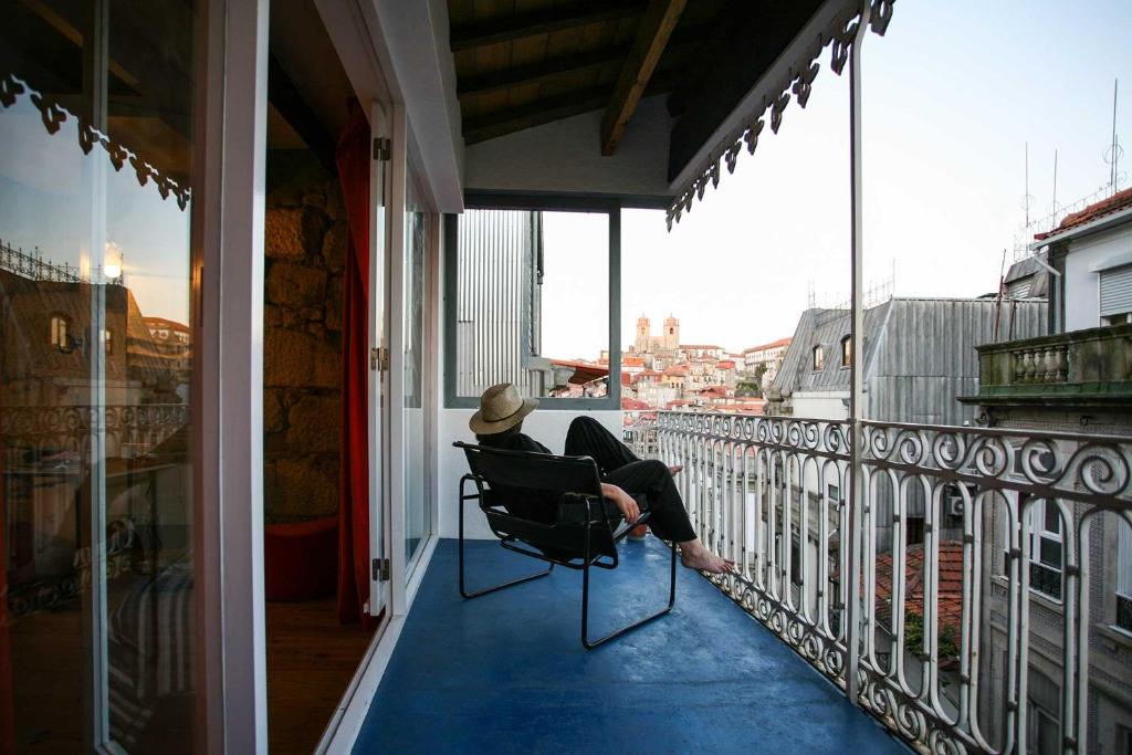 波尔图Belomonte 20 Apartments Porto World Heritage的坐在阳台上椅子上的女人