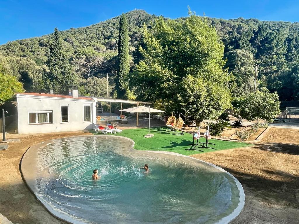 阿雷尼斯-德蒙特CASA RURAL EL JARDI con Piscina, Jardin y Barbacoa的两人在后院的游泳池游泳