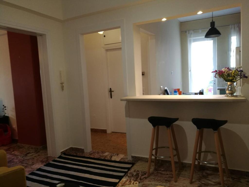 雅典Maria's Cozy apartment in Palaio Faliro的厨房配有柜台和2个酒吧凳