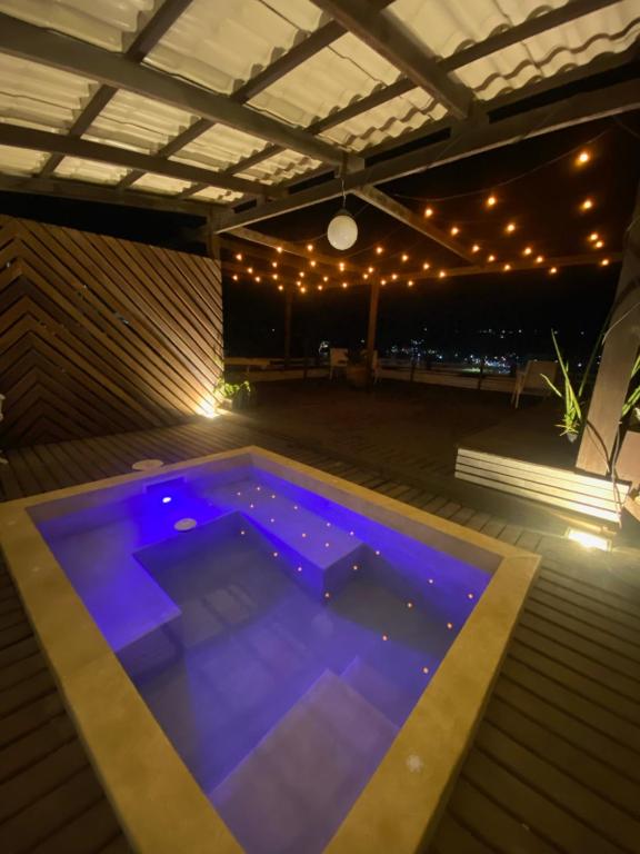 阿拉亚尔-杜卡布Villa Rustica Praia dos Anjos的夜间游泳池,灯光照亮