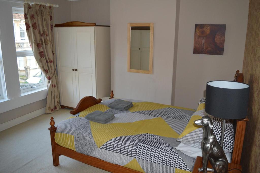 巴斯The Crandale House Vacation Home的一间卧室配有一张黄色和蓝色毯子的床