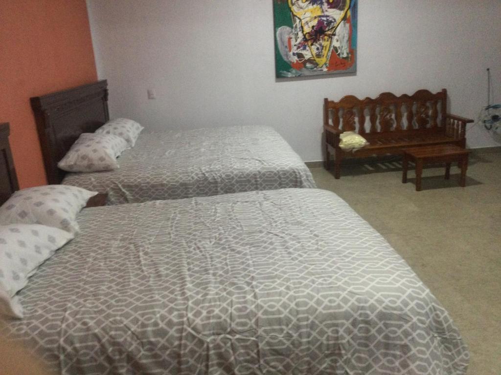 San Agustin de las JuntasCasa alebrijes的一间卧室配有两张床和一张桌子