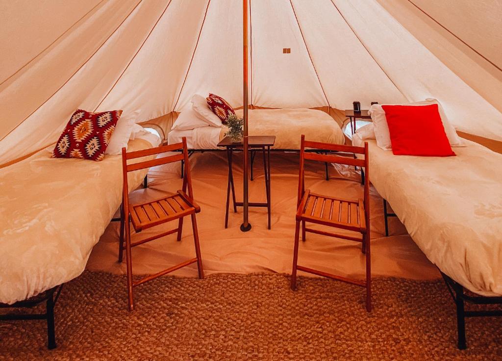 佳能威尔Wander Camp Bryce Canyon - Escalante的帐篷内的两张床,配有两把椅子和一张桌子