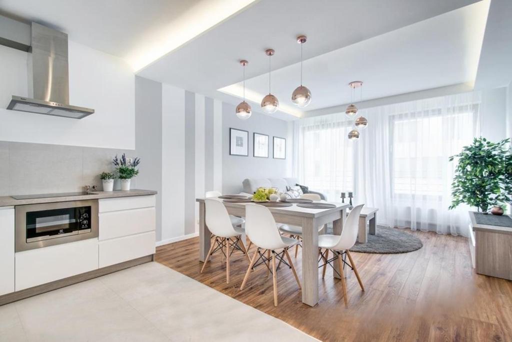 克拉科夫Apartment Masarska的厨房以及带桌椅的用餐室。