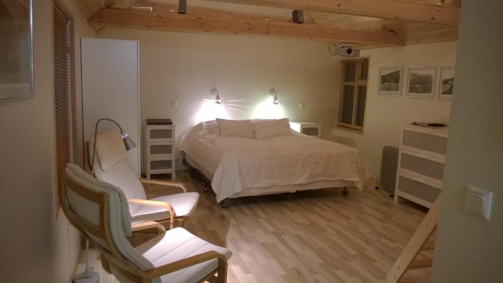 伊萨菲尔德舒适度假屋的一间卧室配有一张床和一把椅子
