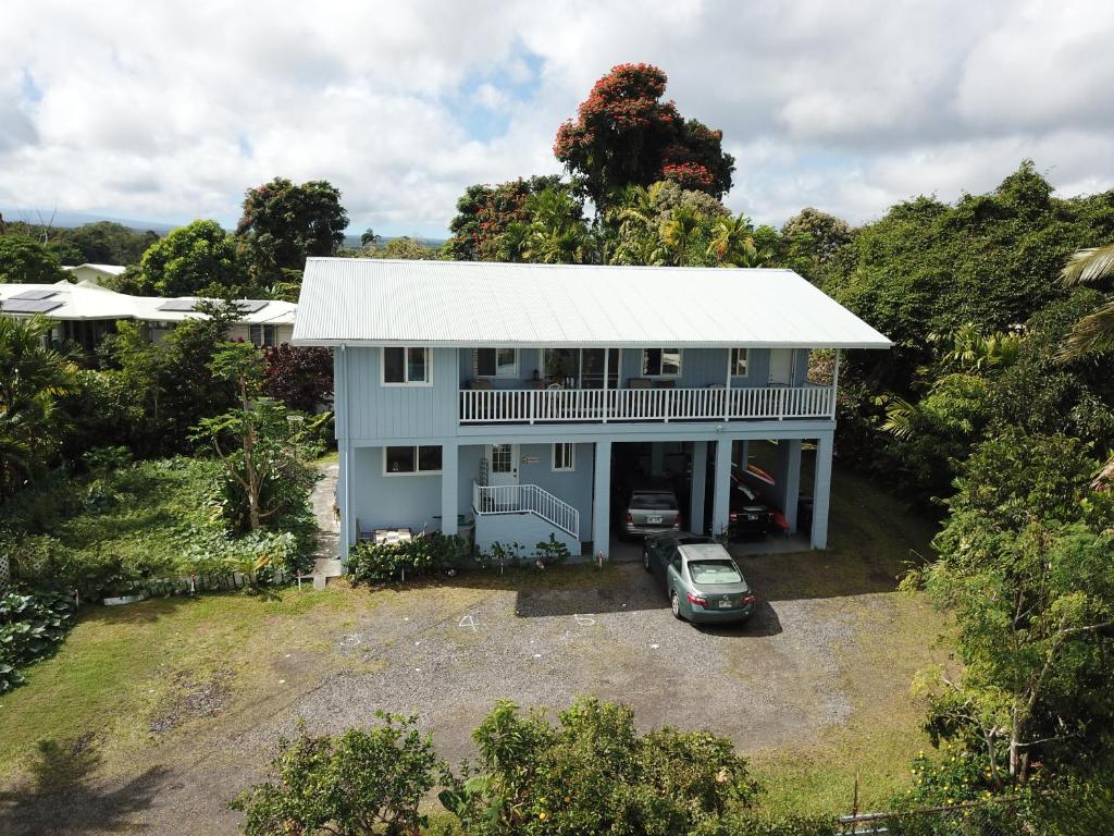 希洛夏威夷奥纳之家住宿加早餐旅馆的蓝色房子的空中景观与汽车