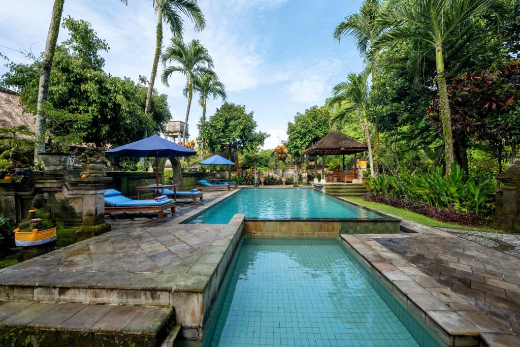 乌布Alam Jiwa Ubud的棕榈树度假村的游泳池